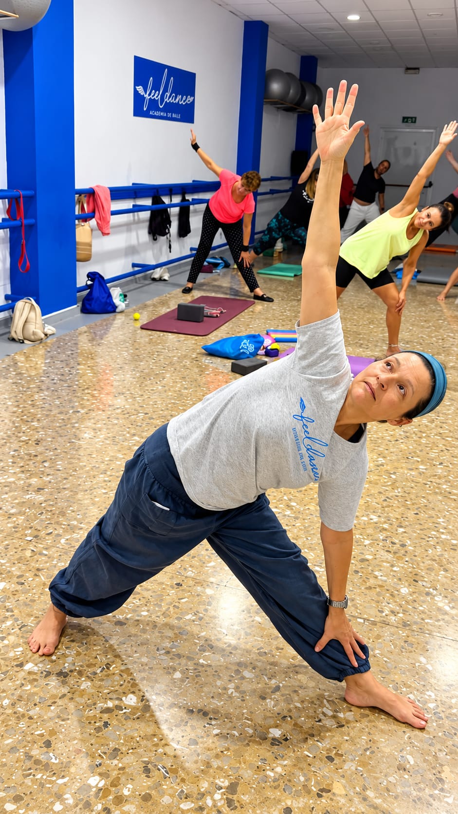 Clase de bienestar en Feel Dance, con una postura de estiramiento de cuerpo completo